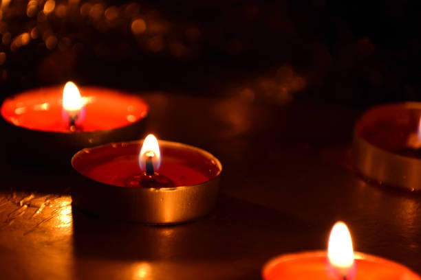 istock Beautiful Tea Candles glowing in dark background 1124497225