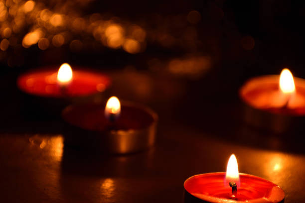 istock Beautiful Tea Candles glowing in dark background 1124497302
