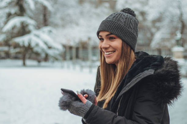 istock Happy girl texting in park covered with snow 1124499114