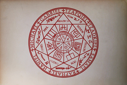 Close-up on the Sigil of the Seven archangels (Michael, Gabriel, Raphael, Zadkiel, Zafqiel, Samael and Haniel), the seven classical planets (Sun, Moon, Mercury, Venus, Mars, Jupiter and Saturn) and the seven  Olympian spirits (Aratron, Bethor, Phaleg, Och, Hagith, Ophiel and Phul) printed on paper.