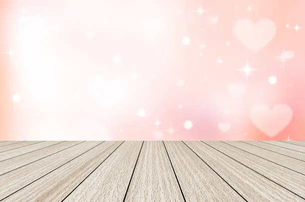 Photo of abstract blur beautiful pink color gradient and white shine flash glowing background with white heart shape blinking star light and modern wood perspective for valentines day 14 february concept