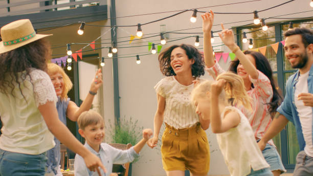 rodzina i przyjaciele tańczą razem na garden party celebration. młodzi i starsi ludzie bawią się na słonecznej dyskotece summer day. - senior women child senior adult outdoors zdjęcia i obrazy z banku zdjęć