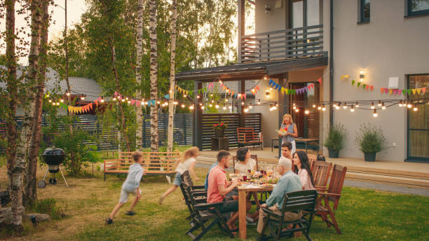 kuvapankkikuvat ja rojaltivapaat kuvat aiheesta big family garden party celebration, kokoontui yhteen pöytäperheeseen, ystäviin ja lapsiin. ihmiset juovat, läpäistään astioita, vitsaillaan ja pidetään hauskaa. lapset juoksevat pöydän ympärillä. - party social event