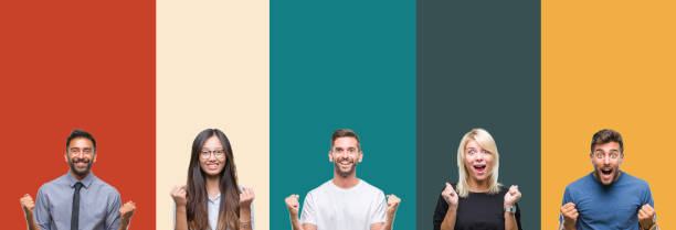 istock Collage of different ethnics young people over colorful stripes isolated background celebrating surprised and amazed for success with arms raised and open eyes. Winner concept. 1124503220