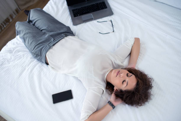 istock Businesswoman Resting on Hotel Bed 1124503604