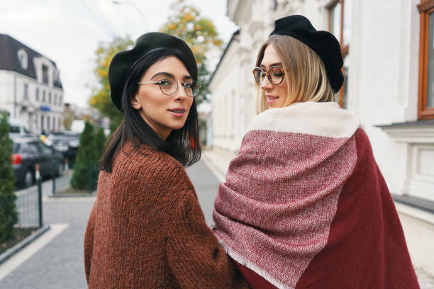 istock Pretty stylish girls looking over shoulder, smiling 1124505417