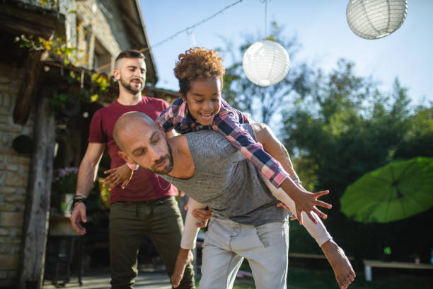 istock Same sex parents having fun with their adopted daughter 1124507702