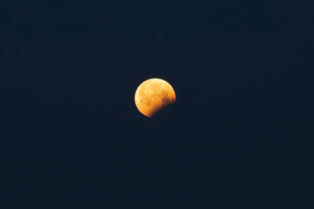 istock Moon Eclipse with a yellow or orange color in the sky 1124509305