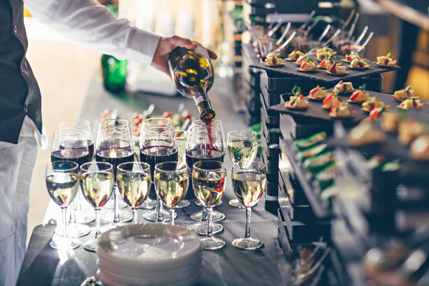 The waiter pours wine into glasses. Event catering concept. stock photo