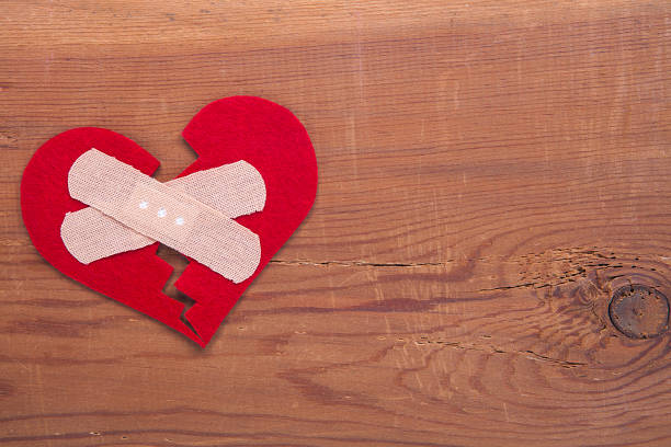 Tiny red heart sign isolated on wooden background. Red heart sign isolated on wooden background. Heart broken, love and valentines day concept. pulse orlando night club & ultra lounge stock pictures, royalty-free photos & images