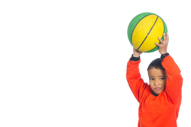 ​A bright orange basketball with a characteristic texture and black lines lies on a contrasting yellow background. This minimalist sports composition symbolizes an active lifestyle,