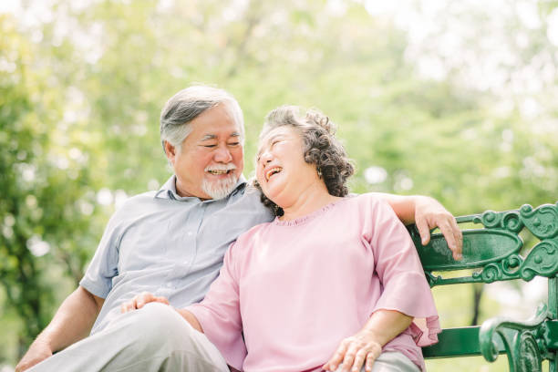 公園で笑っているアジア シニア カップル - senior couple ストックフォトと画像