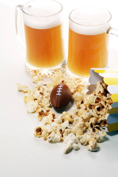 istock popcorn, football and Beer on a table. Great for Bowl Game 1124512222