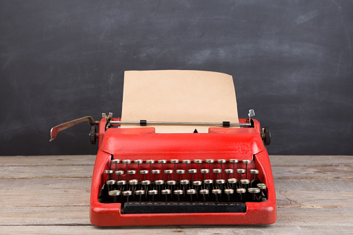 Typewriter on the blackboard background - blogging and writing concept