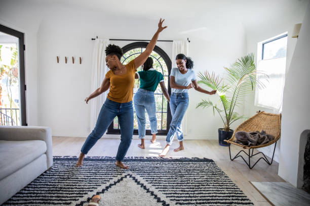 Women friends having fun at home dancing and singing in the living room Women friends having fun at home dancing and singing in the living room of their Los Angeles apartment. dancing stock pictures, royalty-free photos & images