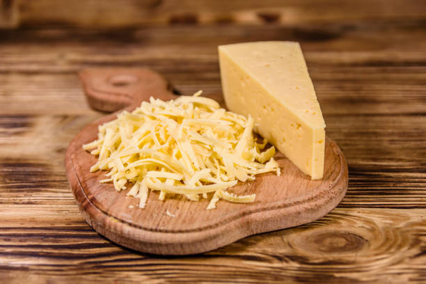 istock Cutting board with grated cheese on wooden table 1124522479