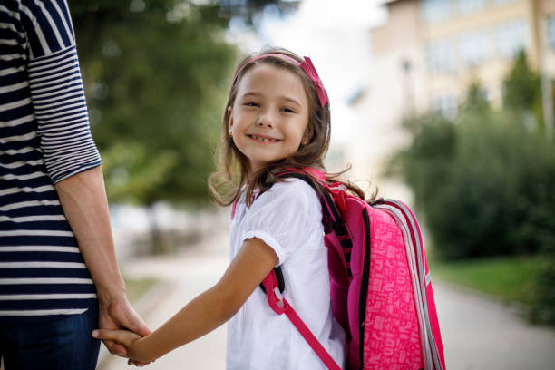 Mother taking her daughter to school stock photo