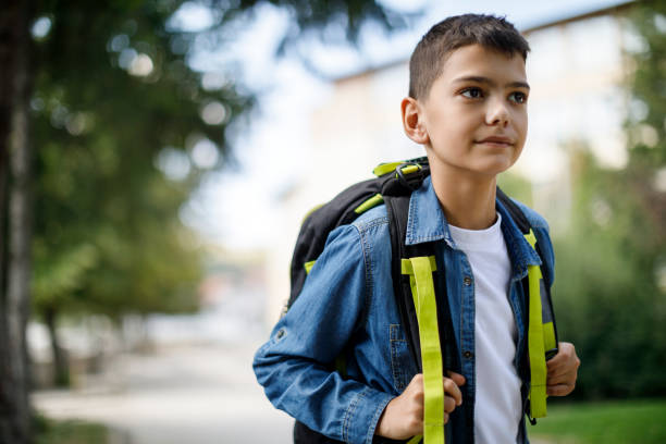 istock Teenage boy with school bag going home from school 1124522770