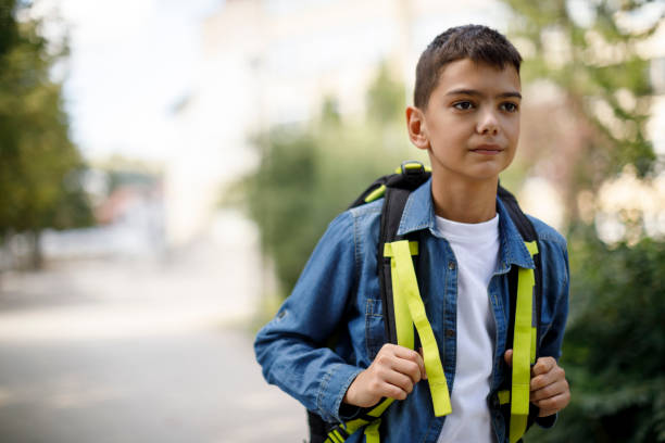 istock Teenage boy with school bag going home from school 1124522911