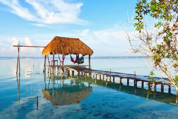 Photo of A couple on hammocks in a palapa over the water at Caribbean.