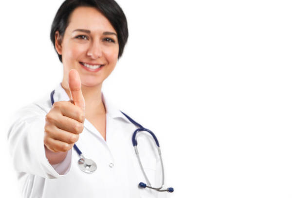 Female doctor is smiling while looking at camera with thumb up
