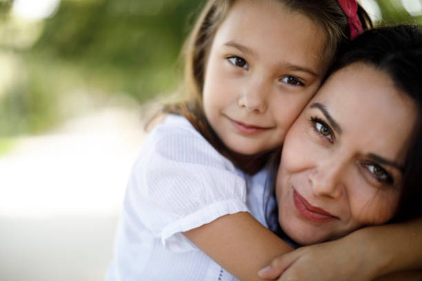 mother and daughter enjoying love and hugging outdoors - babies and children close up horizontal looking at camera imagens e fotografias de stock