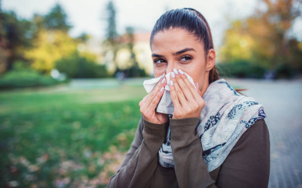 istock Cold and flu. Woman blowing her nose with a tissue 1124529048