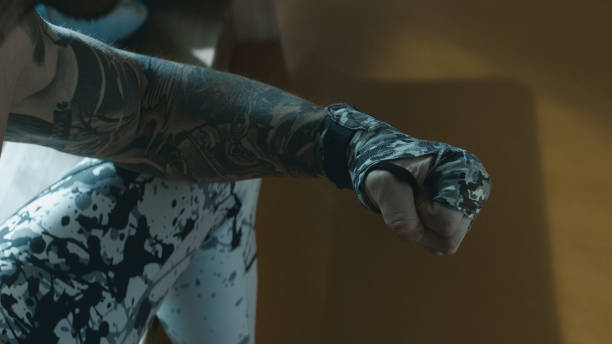 istock Tattooed boxer wrapping hand with tape 1124529201