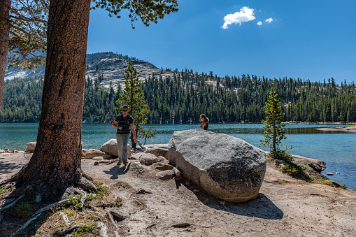 A young girl and a boy are walking along the shores of Tenaya Lake, Yosemite, California, USA,Nikon D3x