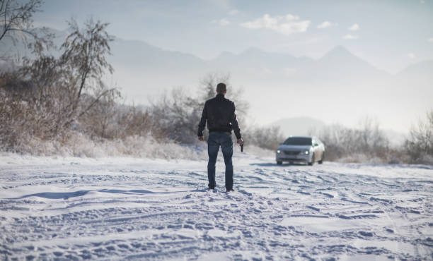 istock crime man with gun outdoors, winter 1124530561