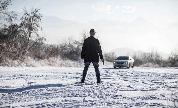 istock crime man with gun outdoors, winter 1124531306