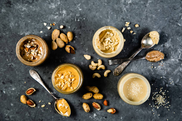 Selection of nut butters - peanut, cashew, almond and sesame seeds stock photo