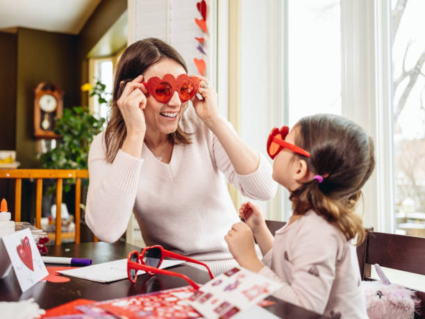 мать и маленькая дочь крафта на день святого валентина - fun mother sunglasses family стоковые фото и изображения