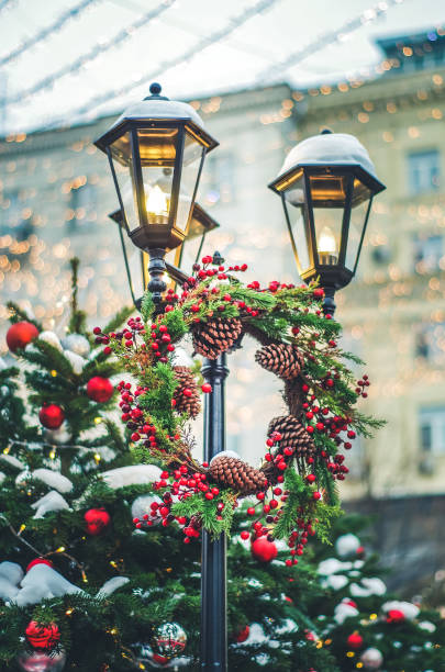 Street lamp decorated with christmas wreath (pine cones, red berries, fir bunch)