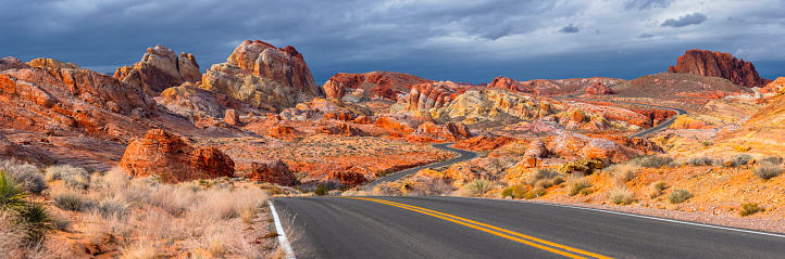 Empty desert road panorama surrounded by red rocks