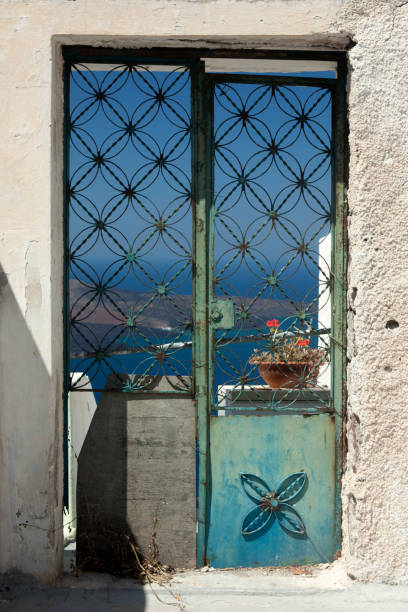 utformad väderbitna dubbeldörr i santorini, grekland - santorini door sea gate bildbanksfoton och bilder