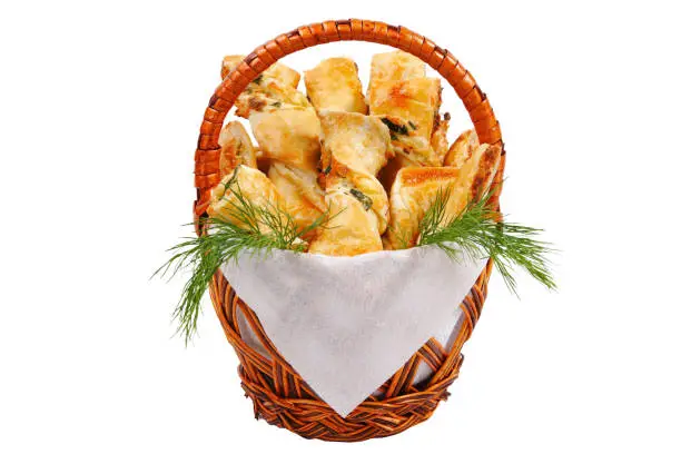 Basket with bread, parsley and a napkin on a white background