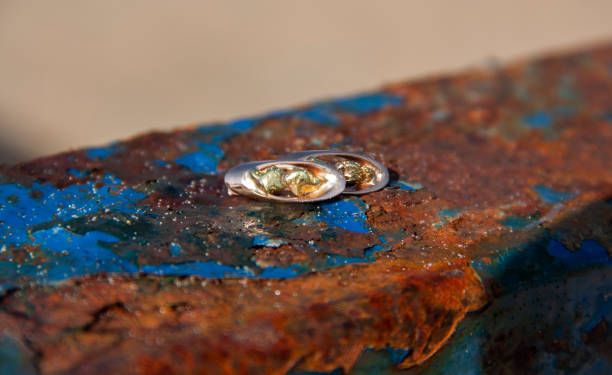 istock Gold earrings with nuggets lie on a rusty metal surface. Close-up shot. 1124542069