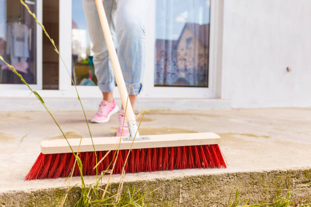 istock Person cleaning patio using brush broom 1124547643