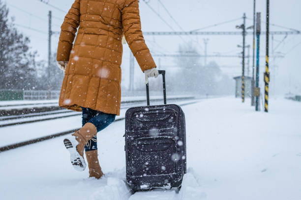 frau, schweres gepäck am bahnhof schnee ziehen. - leaving loneliness women railroad track stock-fotos und bilder