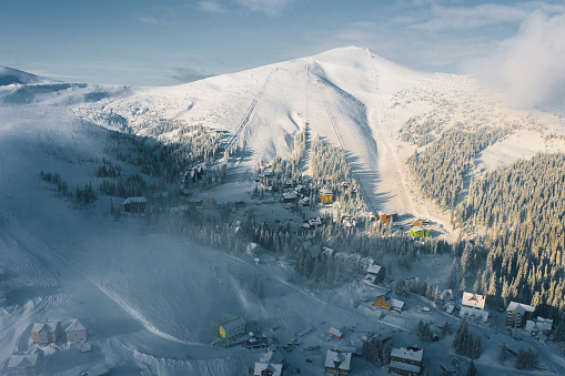 Scenic aerial view of Carpathian mountains in fog in winter