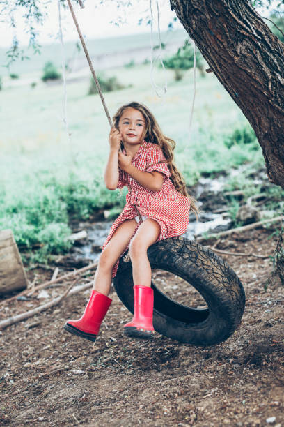 Tire Swing Cute Little girl swinging on a tire tire swing stock pictures, royalty-free photos & images