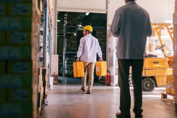 istock Two men working in the storage. Selective focus on man with demijohns in hands. 1124556247