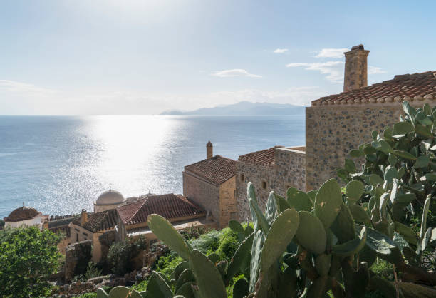 Monemvasia, small rocky peninsula next to Peloponnese with small settlement, located in Greece. View from the town Gefira before sunset, with soft sunlight