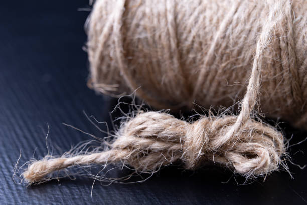 istock Twine for wrapping packages on the table. Jute string wrapped around the roller. Dark background. 1124566349