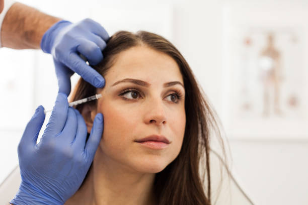 mujer joven en la oficina de cosmetóloga - attractive female human collagen syringe injecting fotografías e imágenes de stock