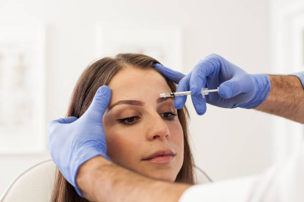 istock Young Woman at a Cosmetologist's Office Getting Botox Injections 1124567539