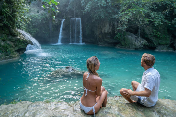 istock Young couple contemplating beautiful tropical waterfall 1124570509