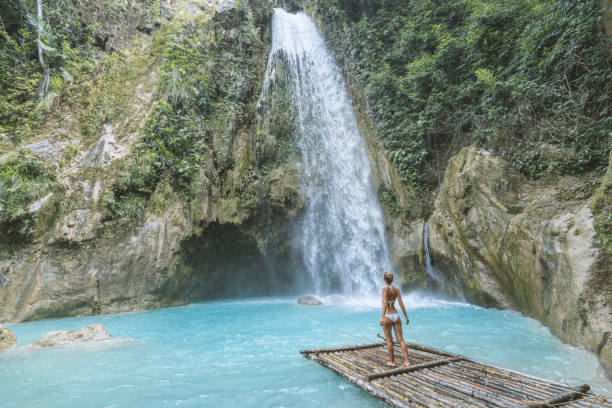 istock Girl contemplating beautiful waterfall 1124570592