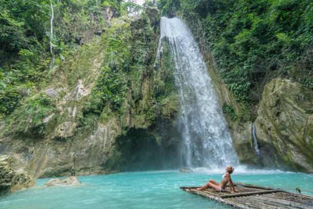 istock Girl contemplating beautiful waterfall 1124570633